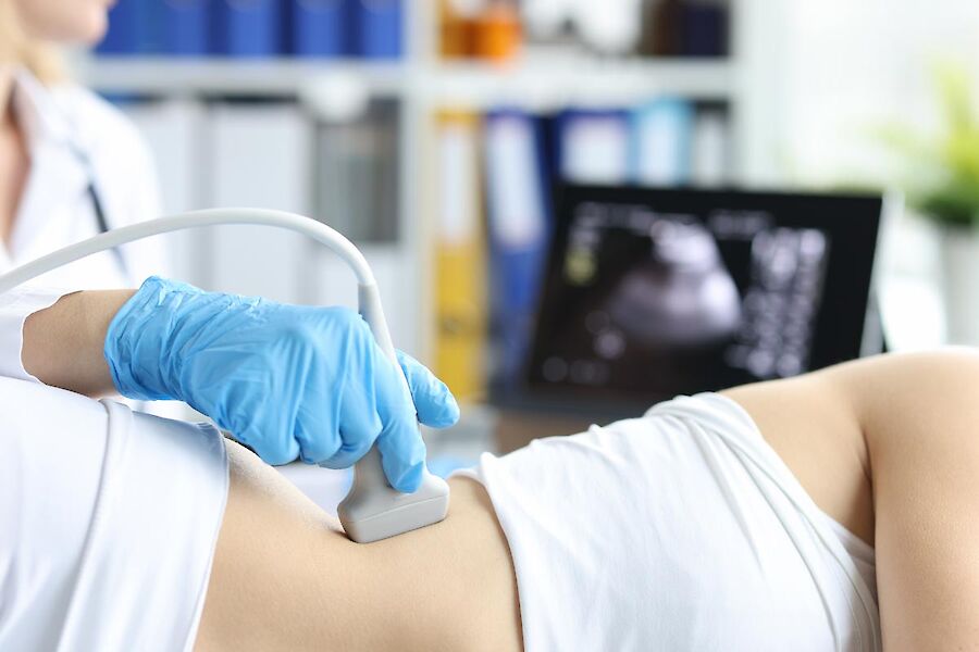 Bauch einer Patientin wird mit einer Ultraschallsonde untersucht.